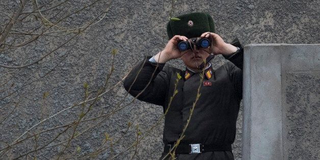 A North Korean soldier uses his binoculars to look across the Yalu river near Sinuiju, opposite the Chinese border city of Dandong on April 14, 2017.A conflict over North Korea could break out 'at any moment', China's Foreign Minister Wang Yi said on April 14, warning there would be 'no winner' in any war as tensions soar with the US. / AFP PHOTO / Johannes EISELE (Photo credit should read JOHANNES EISELE/AFP/Getty Images)