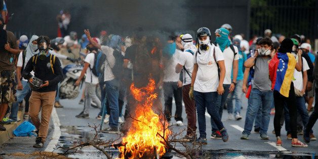 Demonstrators burn tire during a rally against Venezuela's President Nicolas Maduro in Caracas, Venezuela April 24, 2017. REUTERS/Carlos Garcia Rawlins