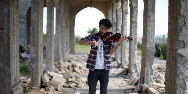 Ameen Mukdad, a violinist from Mosul who lived under ISIS's rule for two and a half years where they destroyed his musical instruments, performs at Nabi Yunus shrine in eastern Mosul, Iraq, April 19, 2017. REUTERS/ Muhammad Hamed