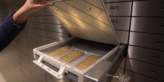 One ounce 24 carat gold bars are placed into a safety deposit box at the Sharps Pixley Ltd gold showroom, in this arranged photograph in London, U.K., on Monday, Jan. 11, 2016. The metal posted the biggest weekly gain since August last week as escalating concerns about China's outlook, a rout in equities and increased geopolitical tensions in the Middle East and North Korea stoked investors' aversion to risk. Photographer: Simon Dawson/Bloomberg via Getty Images