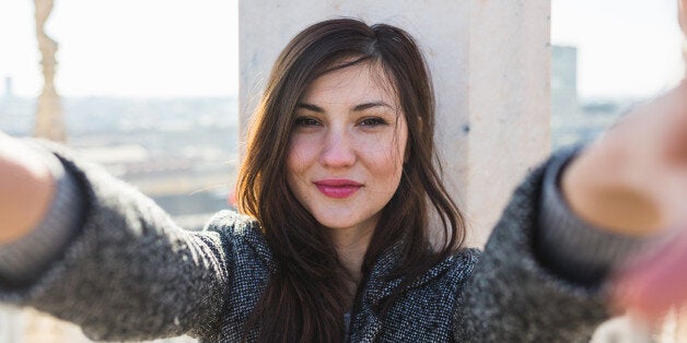 beautiful young woman takes a selfie on the roof of Milan Cathedral.