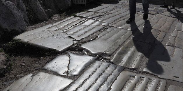 Street pavement (backlit view) made of ancient marble slabs just outside the Acropolis of Athens, Greece.