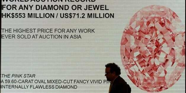 David Bennett, head of Sotheby's International Jewellery Division, walks past a display after a 59.60-carat giant diamond named the 'Pink Star' broke the world record for a gemstone sold at auction, fetching 71.2 million USD, in Hong Kong on April 4, 2017.The pink diamond broke the world record for a gemstone sold at auction, after it fetched 71.2 million USD in Hong Kong on April 4, 2017. / AFP PHOTO / Anthony WALLACE (Photo credit should read ANTHONY WALLACE/AFP/Getty Images)