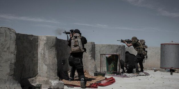 MOSUL, IRAQ - APRIL 10: Iraqi Counter Terrorism Service (ICTS) soldiers fire at Islamic State fighters in Al Yarmuk, west Mosul, April 10, 2017. The ICTS retook the district. Iraqi forces must fight Islamic State street to street as they battle to retake Mosul, part of the offensive to retake the city some two years after it fell to Islamic State. (Photo by Martyn Aim/Corbis via Getty Images)