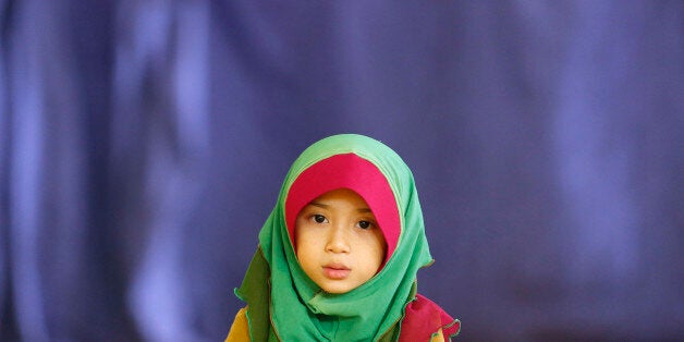 Young Malaysian Muslim, Aisyah Fatoni, 6, reads a prayer as she waits for her father performing Asr prayer during the month of Ramadan at a mosque in Kuala Lumpur July 15, 2013. Ramadan, which began last Wednesday in Muslim-majority Malaysia, is the holiest month of the Islamic calendar. REUTERS/Bazuki Muhammad (MALAYSIA - Tags: SOCIETY RELIGION)