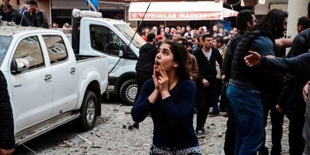 A woman reacts as she looks at the site of a strong blast near the riot police headquarters in the center of Diyarbakir, southeastern Turkey, on April 11, 2017. The explosion which shook police headquarters in Diyarbakir on Tuesday morning was an accident which occurred during repair work. According to Turkey's Interior Minister, no external forces had been involved in the incident in the restive majority Kurdish city which happened during repair work on armoured vehicles at police headquarters. He said one person was seriously hurt while another was trapped under rubble. / AFP PHOTO / ILYAS AKENGIN (Photo credit should read ILYAS AKENGIN/AFP/Getty Images)