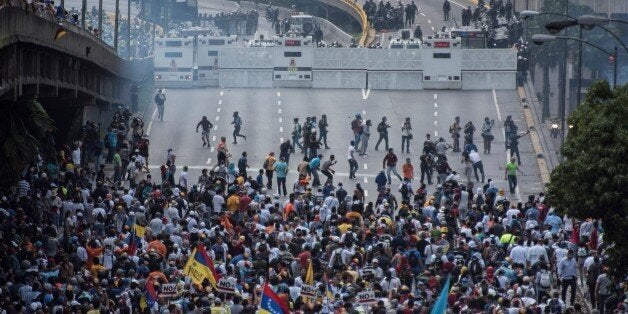 CARACAS, VENEZUELA - APRIL 6: Venezuelan opposition activists clashes wiht Police in Caracas on April 6, 2017. The center-right opposition vowed fresh street protests -after earlier unrest left dozens of people injured - to increase pressure on Maduro, whom they blame for the country's economic crisis. (Photo by Carlos Becerra/Anadolu Agency/Getty Images)