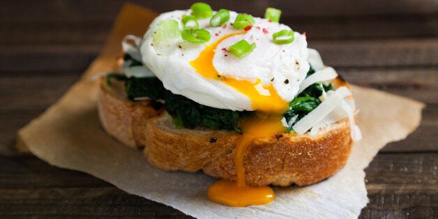 Delicious benedict eggs prepared on a wood table in kitchen