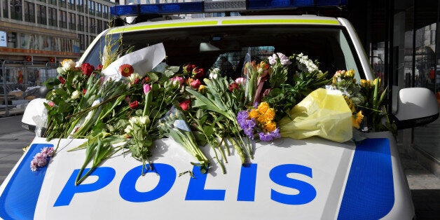 People leaving flowers on a police van outside Ahlens department store following Friday's terror attack in central Stockholm, Sweden, Sunday, April 9, 2017. Jonas Ekstromer/TT News Agency via REUTERS ATTENTION EDITORS - THIS IMAGE WAS PROVIDED BY A THIRD PARTY. FOR EDITORIAL USE ONLY. SWEDEN OUT. NO COMMERCIAL OR EDITORIAL SALES IN SWEDEN