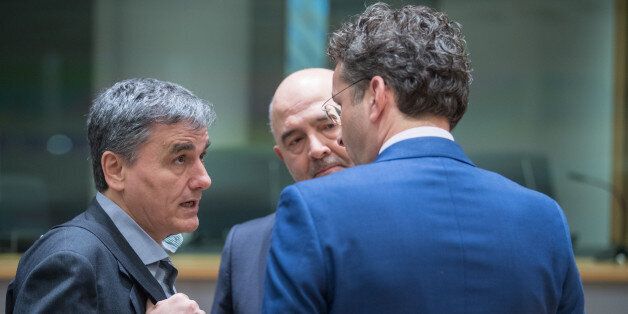 Euclid Tsakalotos, Greece's finance minister, left, speaks with Pierre Moscovici, economic commissioner for the European Union (EU), center, and Jeroen Dijsselbloem, Dutch finance minister and head of the group of euro-area finance ministers, ahead of a Eurogroup meeting of finance ministers in Brussels, Belgium, on Monday, March 20, 2017. Wolfgang Schaeuble, Germany's finance minister, said to reporters ahead of the meeting of euro-area finance ministers Well get a report on Greece, but the mission isnt completed,. Photographer: Jasper Juinen/Bloomberg via Getty Images