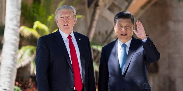 Chinese President Xi Jinping (R) waves to the press as he walks with US President Donald Trump at the Mar-a-Lago estate in West Palm Beach, Florida, April 7, 2017. / AFP PHOTO / JIM WATSON (Photo credit should read JIM WATSON/AFP/Getty Images)