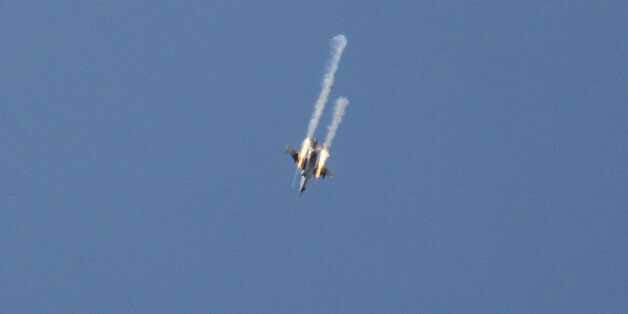 TOPSHOT - A picture taken on March 23, 2017, shows a Syrian army jet firing rockets over the village of Rahbet Khattab in the Hama province.Jihadists and allied rebels claimed more ground against Syrian government forces in central Hama province, the Syrian Observatory for Human Rights monitor said. / AFP PHOTO / Omar haj kadour (Photo credit should read OMAR HAJ KADOUR/AFP/Getty Images)