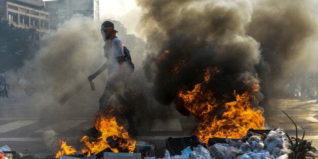 Demonstrators protesting against President Nicolas Maduro's government and riot police clash in Caracas on April 8, 2017. The opposition is accusing pro-Maduro Supreme Court judges of attempting an internal 'coup d'etat' for attempting to take over the opposition-majority legislature's powers last week. The socialist president's supporters held counter-demonstrations on Thursday, condemning Maduro's opponents as 'imperialists' plotting with the United States to oust him. / AFP PHOTO / FEDERICO PARRA (Photo credit should read FEDERICO PARRA/AFP/Getty Images)