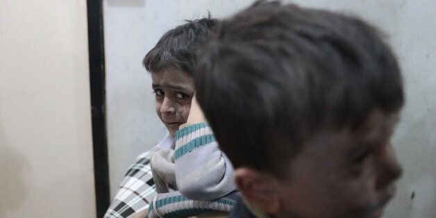 Syrian children wait to receive treatment at a makeshift clinic following reported air strikes by government forces in the rebel-held town of Douma, on the eastern outskirts of Damascus, on April 4, 2017. / AFP PHOTO / Abd Doumany (Photo credit should read ABD DOUMANY/AFP/Getty Images)