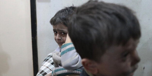 Syrian children wait to receive treatment at a makeshift clinic following reported air strikes by government forces in the rebel-held town of Douma, on the eastern outskirts of Damascus, on April 4, 2017. / AFP PHOTO / Abd Doumany (Photo credit should read ABD DOUMANY/AFP/Getty Images)