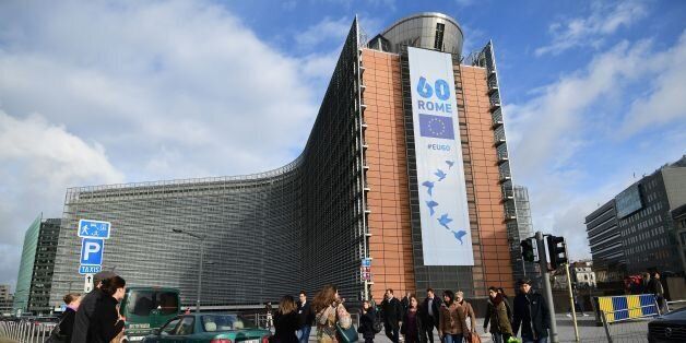 People walk past the European Commission on which is displayed a banner celebrating the 60 years after the signing of the Treaty of Rome, in Brussels on March 21, 2017. European Union leaders gather in Rome this week to proclaim their 'common future' on the bloc's 60th birthday, despite a wave of crises including Britain's looming exit from the bloc. / AFP PHOTO / EMMANUEL DUNAND (Photo credit should read EMMANUEL DUNAND/AFP/Getty Images)