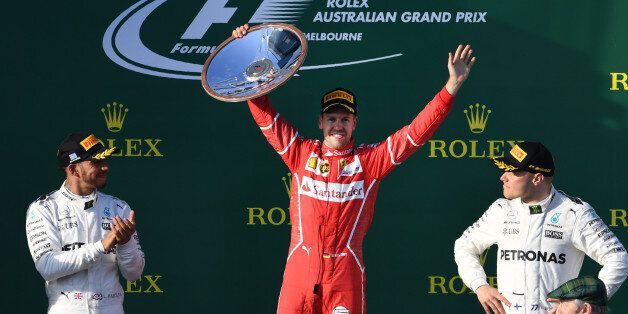 Ferrari's German driver Sebastian Vettel (C) celebrates on the podium with Mercedes' British driver Lewis Hamilton (L) and Mercedes' Finnish driver Valtteri Bottas (R) after winning the Formula One Australian Grand Prix in Melbourne on March 26, 2017. / AFP PHOTO / WILLIAM WEST / -- IMAGE RESTRICTED TO EDITORIAL USE - STRICTLY NO COMMERCIAL USE -- (Photo credit should read WILLIAM WEST/AFP/Getty Images)