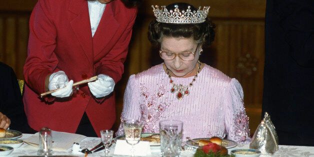 PEKING, CHINA - OCTOBER 13: Queen Elizabeth ll is offered chopsticks as she studies her food during a State Banquet on October 13 ,1986 in Peking, China. The Queen is wearing the tiara known as 'Granny's Tiara' and a pink dress decorated with tree peony blossom, the national flower of China, designed by Ian Thomas. (Photo by Anwar Hussein/Getty Images)