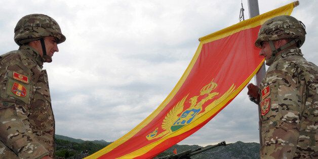 Montenegrin Army soldiers fire artillery look at the Montenegro flag during preparations on the eve of Independence day, on May 20, 2010 in Cetinje. Montenegro, a former Yugoslav Republic with a population of around 650,000, split away from a loose union with Serbia four years ago after a historic independence referendum. AFP PHOTO / Savo PRELEVIC (Photo credit should read SAVO PRELEVIC/AFP/Getty Images)