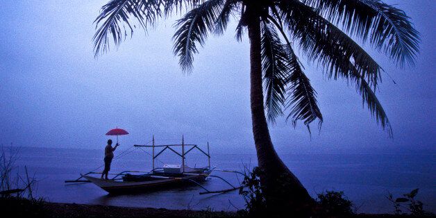 A fisherman surveys a tropical storm brewing in Gumacas bay in what is known as 'typhoon alley' in north eastern Philippines near Busok Busok fishing village a region frequently hit by deadly and violent typhoons. (Photo by Christopher Pillitz/Getty Images)