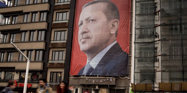 ISTANBUL, TURKEY - MARCH 13: People walk past a large banner showing the portrait of Turkish President Recep Tayyip Erdogan in Taksim Square on March 13, 2017 in Istanbul, Turkey. Turkey will hold its constitutional referendum on April 16, 2017. Turks will vote on 18 proposed amendments to the Constitution of Turkey. The controversial changes seek to replace the parliamentary system and move to a presidential system which would give President Recep Tayyip Erdogan executive authority. Campaigning will officially begin on February 25 with a pro referendum rally to be held in Ankara and attended by Prime Minister Binali Yildirim. (Photo by Chris McGrath/Getty Images)