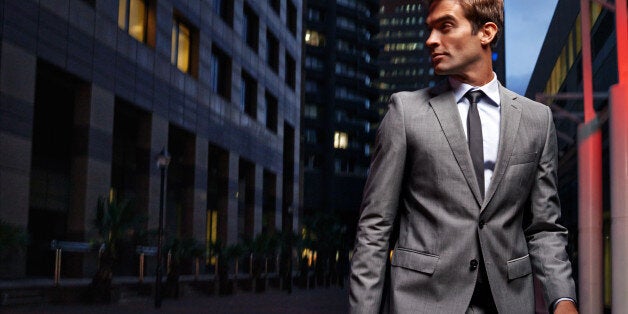 Shot of a handsome businessman in a suit walking through the city at night