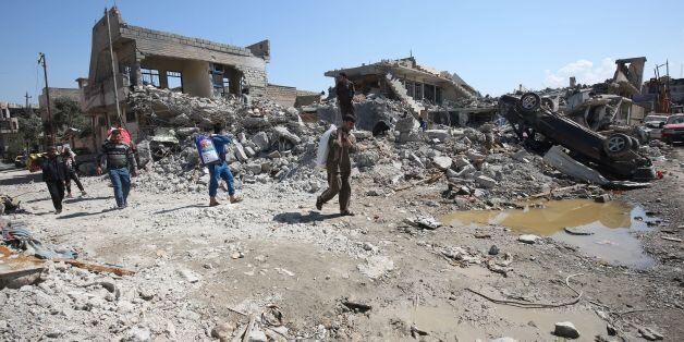Iraqis inspect the damage in Mosul's al-Jadida area on March 26, 2017, following air strikes in which civilians have been reportedly killed during an ongoing offensive against the Islamic State (IS) group. Iraq is investigating air strikes in west Mosul that reportedly killed large numbers of civilians in recent days, a military spokesman said. / AFP PHOTO / AHMAD AL-RUBAYE (Photo credit should read AHMAD AL-RUBAYE/AFP/Getty Images)