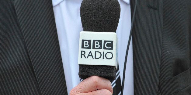 A man holds a BBC radio microphone as he is interviewed at Heathrow airport in west London May 12, 2011. REUTERS/Toby Melville (BRITAIN - Tags: SOCIETY MEDIA)