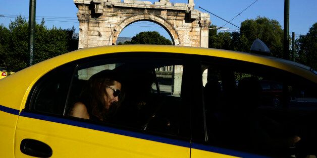 A woman rides in a taxi past an ancient site in Athens May 5, 2012. A ban on campaigning took effect in Greece on Saturday 24 hours ahead of the most uncertain and critical election for decades, a vote that could throw the country's future in Europe into doubt and shake the common currency. REUTERS/Kevin Coombs (GREECE - Tags: POLITICS CIVIL UNREST ELECTIONS)
