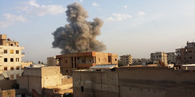 RAQQA, SYRIA - NOVEMBER 25 : Smoke rises after air strikes by Syrian army warplanes on the ISIL-held northern city of Raqqa, Syria on November 25, 2014. At least 130 people have been killed when Syrian war planes struck in Raqqa. (Photo by Stringer/Anadolu Agency/Getty Images)