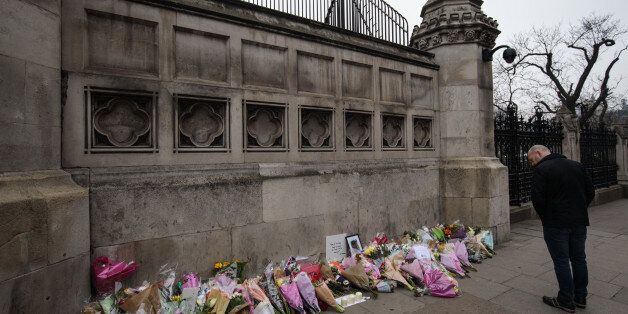 LONDON, ENGLAND - MARCH 24: A man pauses in front of floral tributes laid outside the the Houses of Parliament following Wednesday's attack on Westminster on March 24, 2017 in London, England. A fourth person has died after Khalid Masood drove a car into pedestrians on Westminster Bridge before going on to fatally stab PC Keith Palmer on March 22. (Photo by Jack Taylor/Getty Images)