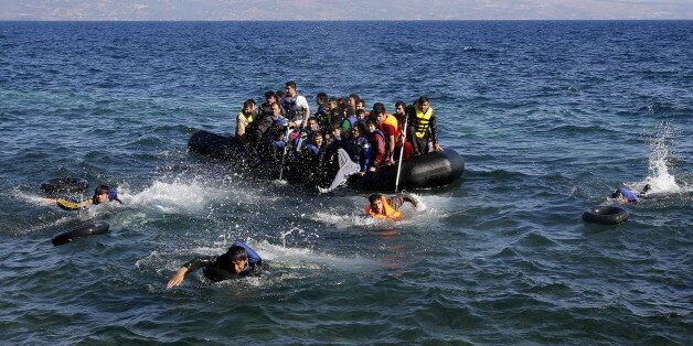 Afghan and Syrian refugees struggle to swim from a dinghy with a broken engine that drifts out of control to a rocky beach on the Greek island of Lesbos after crossing a part of the Aegean Sea from Turkey September 18, 2015. REUTERS/Yannis Behrakis
