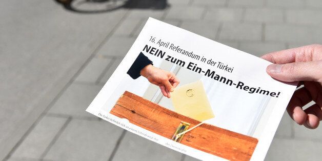 A man holds a flyer with the inscription 'April 16 - referendum in Turkey - No to the one-man regime!' in front of a polling station in the Bavarian city of Munich, southern Germany, on March 27, 2017. Turkish expatriates in Germany and five other European countries started casting their ballots Monday in a controversial referendum that could vastly boost President Recep Tayyip Erdogan's powers. / AFP PHOTO / Christof STACHE (Photo credit should read CHRISTOF STACHE/AFP/Getty Images)