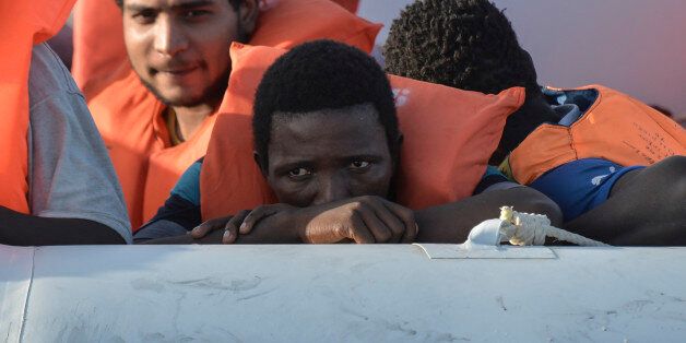 Men wait on a rubber boat to be rescued by the crew of the Topaz Responder ship run by Maltese NGO Moas and the Italian Red Cross during a rescue operation of Migrants and refugees on November 3, 2016, off the Libyan coast in the Mediterranean Sea. / AFP / ANDREAS SOLARO (Photo credit should read ANDREAS SOLARO/AFP/Getty Images)