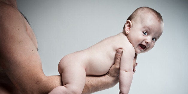 Father holding his pretty baby girl on arms.