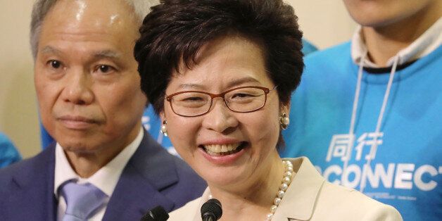 Carrie Lam, Hong Kong's chief executive-elect, center, speaks as her husband Lam Siu-por looks on during a news conference following the chief executive election in Hong Kong, China, on Sunday, March 26, 2017. Hong Kong's former No. 2 official, Lam, was elected as the city's chief executive, giving China its preferred choice to lead the fractious financial hub. Photographer: Paul Yeung/Bloomberg via Getty Images