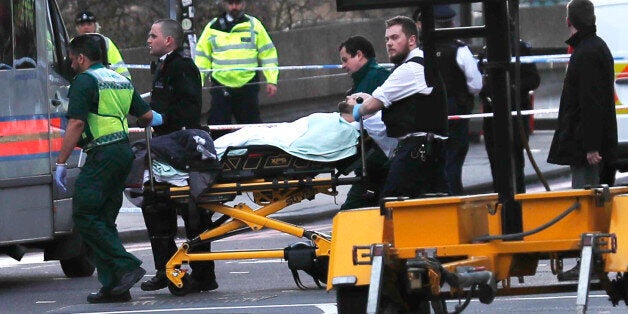 Members of the emergency services take an injured person away on a stretcher after an incident on Westminster Bridge in London, Britain March 22, 2017. REUTERS/Eddie Keogh