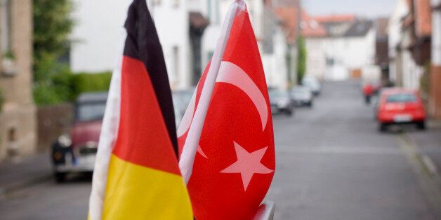 'German and turkish flag on the roof of a car, symbol of friendship,More objects:'