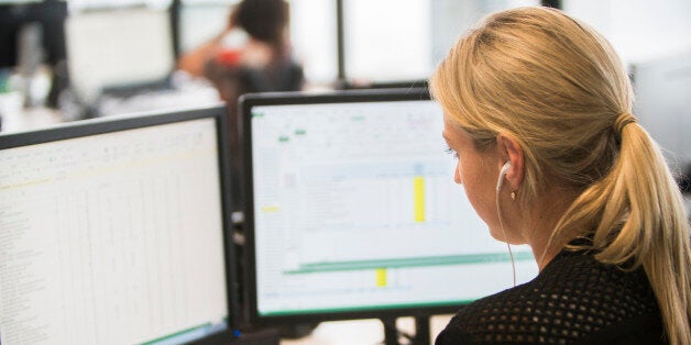 Businesswoman with headset at workstation looking at camera.