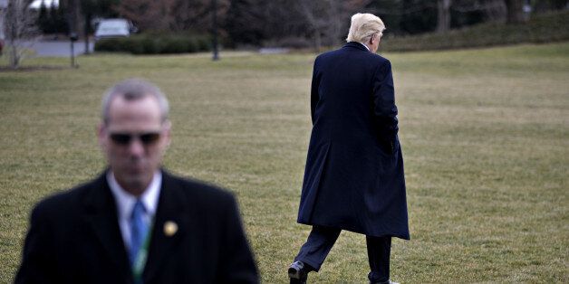 A member of the Secret Service stands watch as U.S. President Donald Trump walks toward Marine One on the South Lawn of the White House in Washington, D.C., U.S., on Friday, Feb. 3, 2017. Trump today signed two directives aimed at staring the process of rolling back the regulatory system put in place after the financial crisis. Among the targets are rules that protect against predatory lenders, force brokers to lower fees for retirees and ban proprietary trading. Photographer: Andrew Harrer/Bloomberg via Getty Images