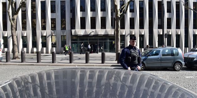 A French Police officer stands guard outside the main entrance of the Paris offices of the International Monetary Fund (IMF) on March 16, 2017 in Paris, after a letter bomb exploded in the premises.An employee at the Paris offices of the International Monetary Fund suffered injuries to her hands and face after opening a letter which exploded on March 16, police said. Several people were evacuated from the building near the Arc de Triomphe monument 'as a precaution', a police source said. / AFP P
