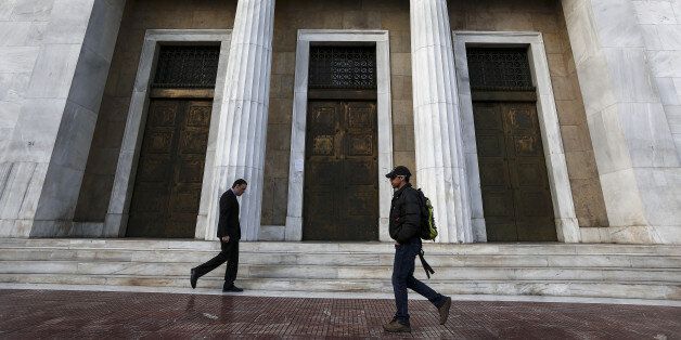 Pedestrians pass the entrance to the headquarters of the Bank of Greece in Athens, Greece, on Tuesday, Feb. 28, 2017. Greeces auditors are pulling together a list of policies the country needs to implement to unlock additional bailout funds as talks with Athens resumed on Tuesday, two people familiar with the matter said. Photographer: Yorgos Karahalis/Bloomberg via Getty Images