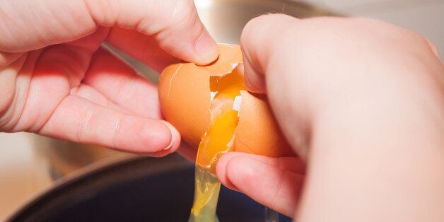 Female hands breaking egg