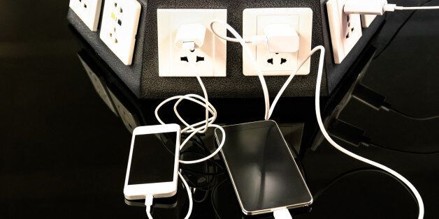 Charging station for mobile smart phones at international airport - Helpful corner for electronical modern technology devices and smartphones