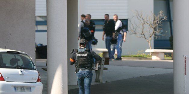 An armed French policeman wearing bulletproof jacket walks at the Tocqueville high school in the southern French town of Grasse, on March 16, 2017 following a shooting that left two people injured.At least eight people were injured in a shooting at a high school in the southern French town of Grasse on March 16, 2017 which saw the head teacher targeted, police and local authorities said. One 17-year-old pupil armed with a rifle, two handguns and two grenades was arrested after the shooting at th