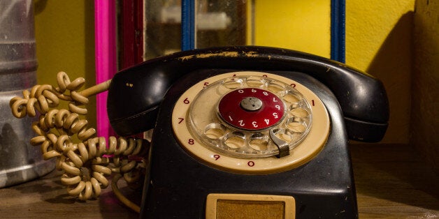 Old black telephone classic on wooden background