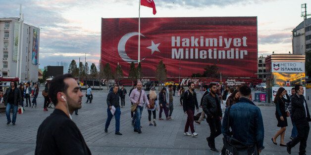 ISTANBUL, TURKEY - SEPTEMBER 26: People walk in front of a billboard posted in Taksim square after the failed coup attempt displaying the words Hakimiyet Milletindir (Sovereignty belongs to the people/nation) on September 26, 2016 in Istanbul, Turkey. Credit rating agency Moody's Investor Services downgraded Turkey's credit rating to 'junk' citing a slowing economy and concerns over the rule of law after the July 15 failed coup attempt. (Photo by Chris McGrath/Getty Images)