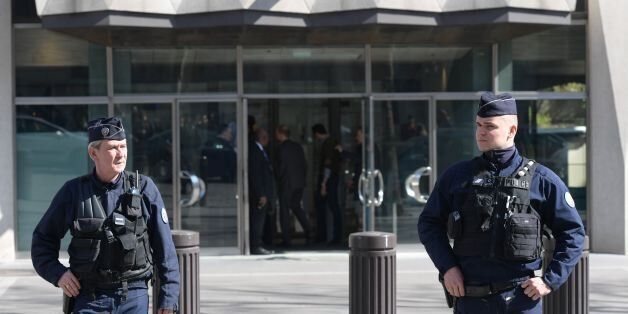 TOPSHOT - Members of the POlice Forensic team leave the Paris offices of the International Monetary Fund (IMF) on March 16, 2017 in Paris, after a letter bomb exploded in the premises.An employee at the Paris offices of the International Monetary Fund suffered injuries to her hands and face after opening a letter which exploded on March 16, police said. Several people were evacuated from the building near the Arc de Triomphe monument 'as a precaution', a police source said. / AFP PHOTO / Christo