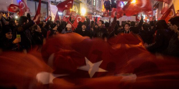ISTANBUL, TURKEY - MARCH 12: Protesters hold a large Turkish flag as they sing songs and chant slogans outside the Dutch Consulate on March 12, 2017 in Istanbul, Turkey. Protesters gathered outside the consulate after the Turkish foreign minister, who was scheduled to speak in the Dutch city of Rotterdam, was refused entry and his plane banned from landing. In response to the action Turkish President Recep Tayyip Erdogan speaking at a referendum rally described the Dutch as ' Nazi remnants and fascists' (Photo by Chris McGrath/Getty Images)
