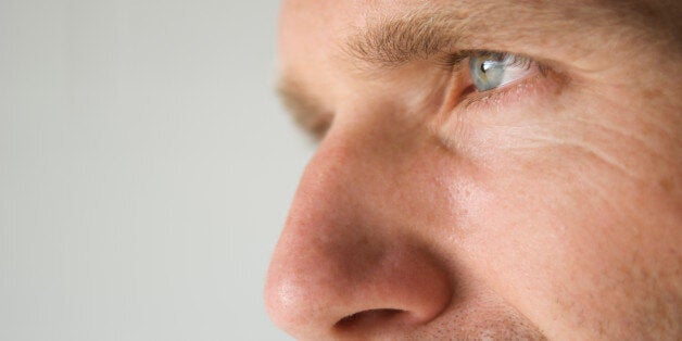 Close-up shot of a man's blue eye and prominent nose